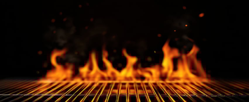 The Flames Dancing Above a Grill in a Dark Atmospheric Setting photo