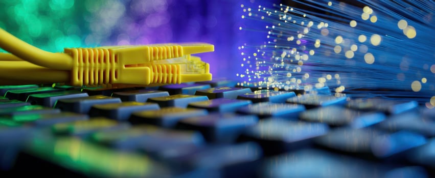 The vibrant connection of a yellow Ethernet cable and fiber optics keyboard. photo