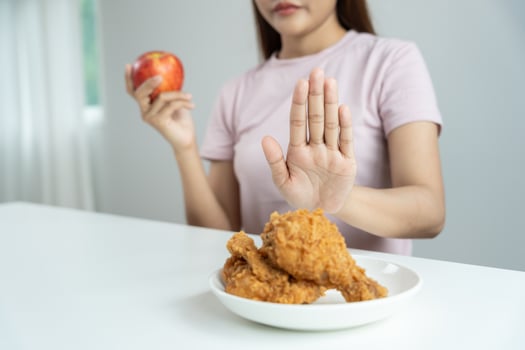 female body confuse fried chicken, Woman in restaurant achieves weight loss goal for healthy life, crazy about thinness, thin waist, nutritionist. Diet, body shape. photo
