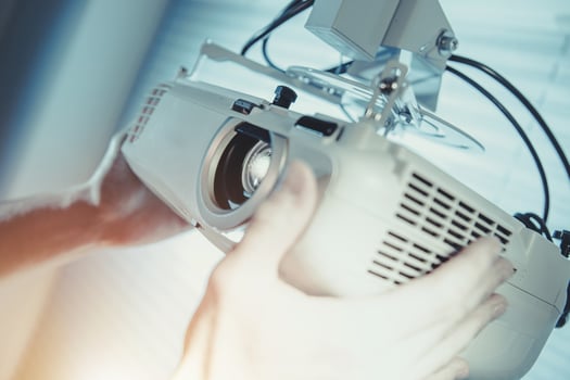 Technician Installs Projector in Modern Office Setting With Natural Light During Daytime photo