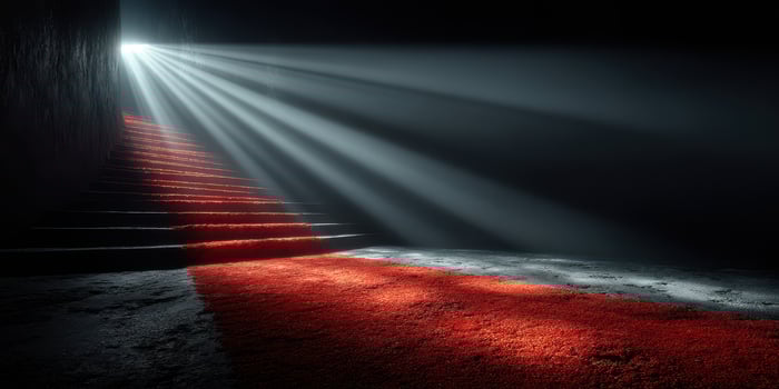 Mysterious red carpet leads up dark stairs illuminated by beams of light photo
