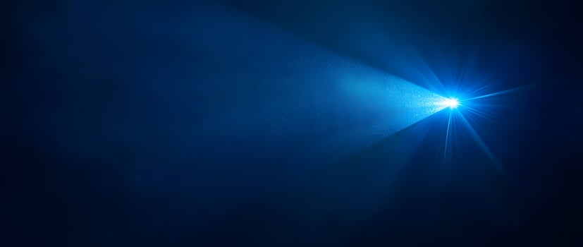 A bright blue spotlight shines brilliantly against the inky backdrop, illuminating specks of suspended particles photo