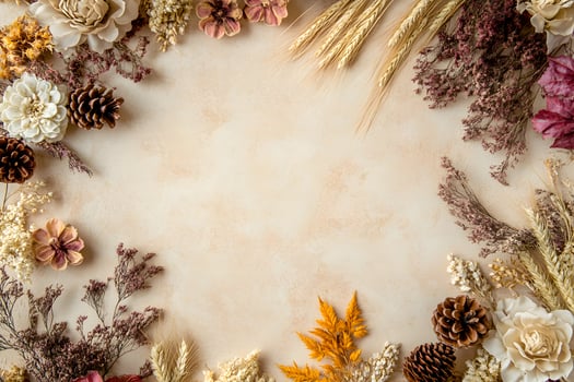 Assorted autumn flowers, wheat stalks, and pinecones create a decorative border on beige texture photo