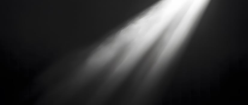 Bright, white beams of light pierce through the dark, misty space elegantly photo