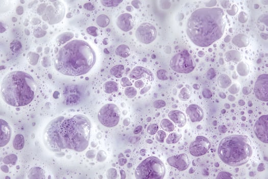 Bubbles of soft lilac foam present an abstract, textured surface for backgrounds and artistic projects photo