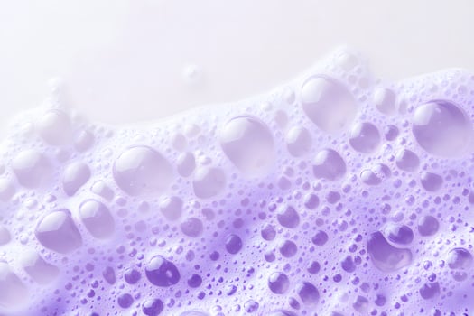 Closeup captures a sea of light purple bubbles blending into a bright white surface photo