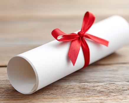 Rolled diploma scroll tied with red ribbon on wooden surface, symbolizing achievement and celebration in education or ceremony photo