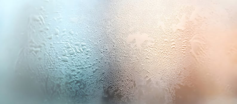 Condensation creates an intricate water droplet pattern on a cold glass pane background photo