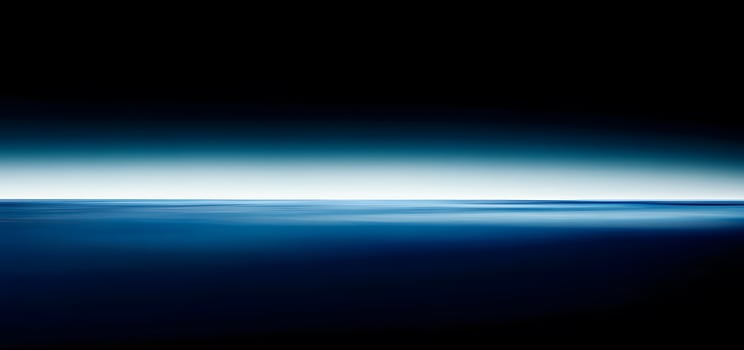 Deep blue water meets a gradient sky in this serene abstract ocean scene photo