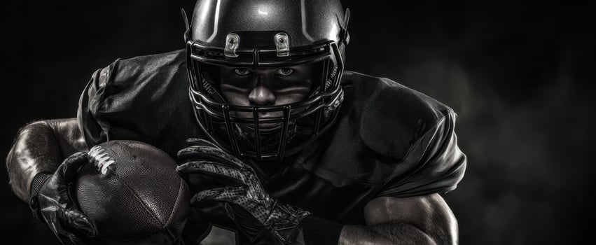 The powerful football player in a dramatic black and intense action pose. photo