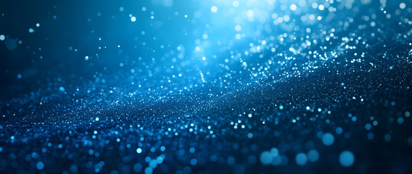 Sparkling blue glitter scatters and shines, creating a magical, ethereal effect in the darkness photo