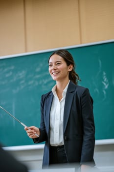 A woman in a suit and tie holding a pointer photo