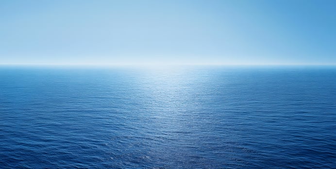 The rippling blue ocean meets the light blue sky in a mesmerizing, seamless blend photo