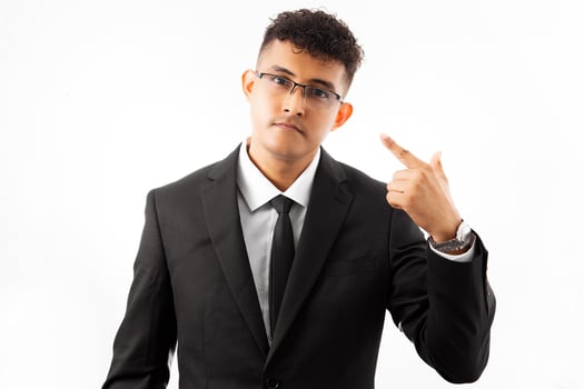 Hispanic adult man wearing business suit using and pointing sign with a finger a eye glasses. photo