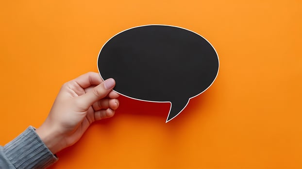 Blank Speech Bubble in Hand on Orange Background for Mockups photo
