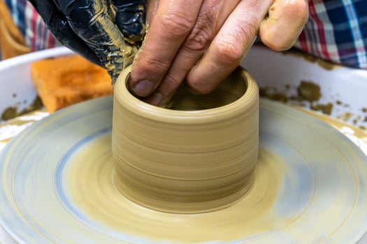 Hands at Work Crafting a Bowl on the Pottery Wheel photo