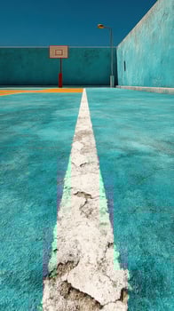 Vibrant blue basketball court with a cracked surface and a hoop under a clear sky photo