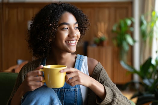 Coffee Background Happy Young Woman with Curly Hair Enjoying Coffee at Home Relaxed and Smiling photo