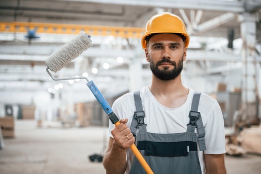 With ,brush, for, coloring. Industrial worker in wooden warehouse photo