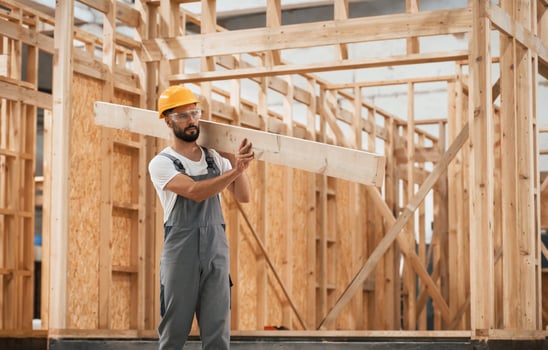 Walking, holding plank.., Industrial worker in wooden warehouse photo