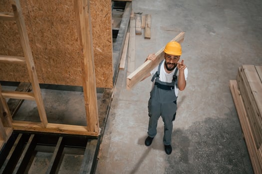 In yellow,, hardhat. Industrial worker in wooden warehouse photo