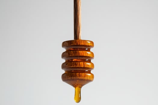 Honey Drips Slowly From a Wooden Dipper Against a Light Background photo