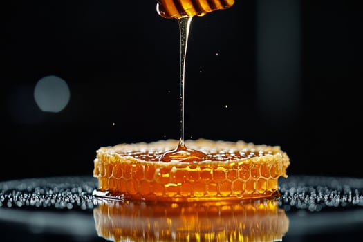 Honey Dripping From a Wooden Dipper Into a Honeycomb on a Dark Background photo