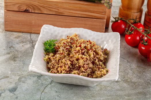 A bowl of quinoa with vegetables and herbs photo