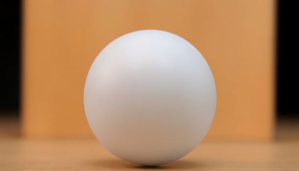 white egg sitting on top of a wooden table photo