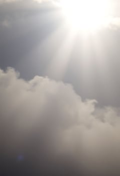 plane flying in the sky with the sun shining through the clouds photo