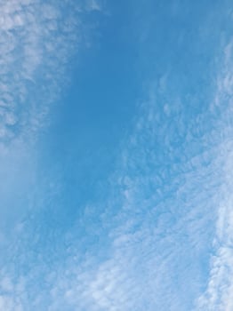 A calm sky filled with soft, scattered clouds, creating a serene and peaceful atmosphere under the gentle blue. photo