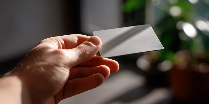 A person holding a silver card in their hand photo