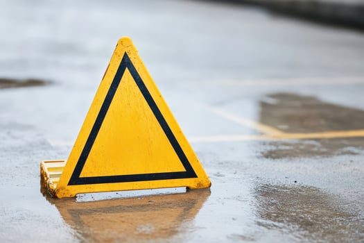 Caution sign on wet pavement in a parking area photo