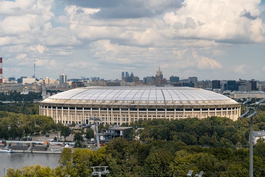A stunning view of Luzhniki Park featuring Moscow City skyscrapers in the background, framed by vibrant greenery and dynamic cloud patterns photo