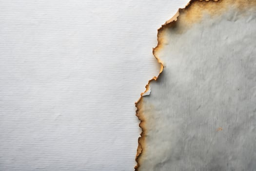 Detailed close-up of aged paper with burnt edges providing a vintage texture photo