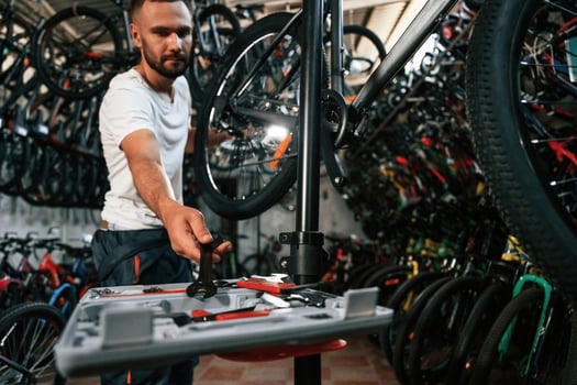 Bunch of tools. Repair man in bicycle shop, working in store photo
