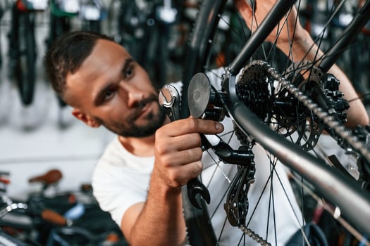 Checking the wheel and brake system., Repair man in bicycle shop, working in store photo