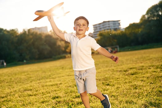 Happy, boy is running with toy plane on the summer field photo