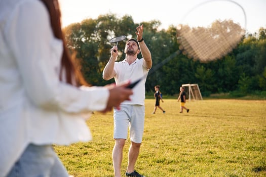 Conception of sports, and hobby. Man with woman are playing badminton on the field photo