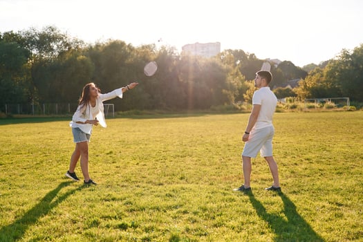 Man with, woman are ,playing badminton on the field photo