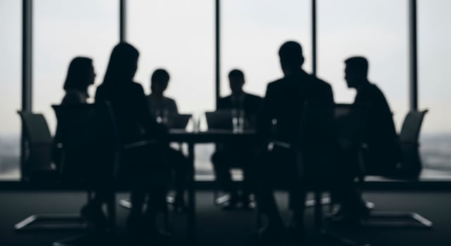 Blurred silhouettes of business professionals in a modern conference room during a corporate meeting. photo