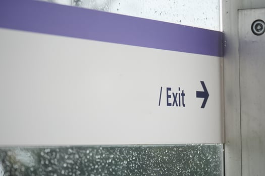 Clear exit sign with directional arrow in rainy setting photo