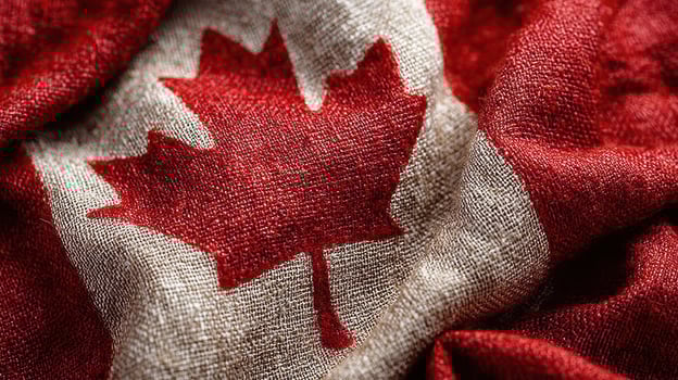 Canadian flag displayed prominently with bold colors and intricate textures at a cultural event during a sunny afternoon photo