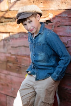 Portrait of a vintage village boy in a cap and denim jacket. Beautiful child from the village. photo