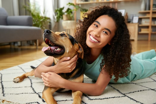 Dog Background Happy Young Woman with Curly Hair Hugging Her Adorable Mixed Breed Dog at Home photo