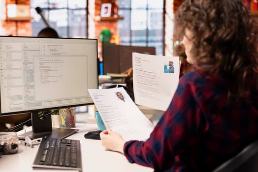 Startup HR worker identifying right candidates for job opening, reviewing resumes to determine qualifications. Woman doing screening process, selecting skilled people for software development position photo