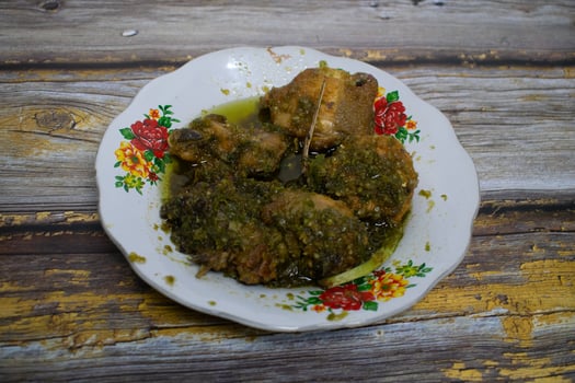 Traditional green chili fried chicken served on floral patterned porcelain plates and rustic wooden table photo