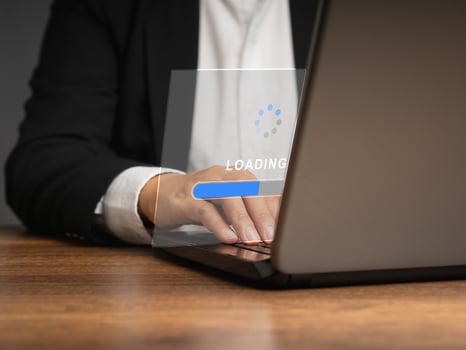 Businessman in a suit uses a laptop for loading and processing data on a virtual screen photo