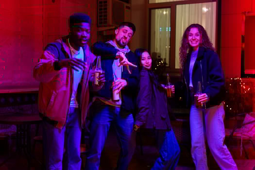 Friends celebrate together in lively indoor setting with colorful lighting at night photo