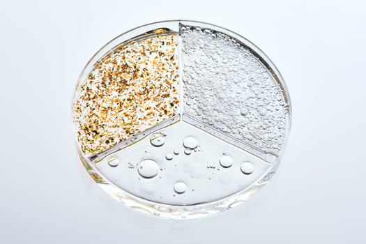 A three-section petri dish with textures of various cosmetic serums. photo
